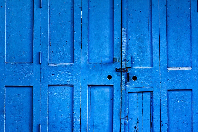 Weathered wooden doors painted vivid blue.
